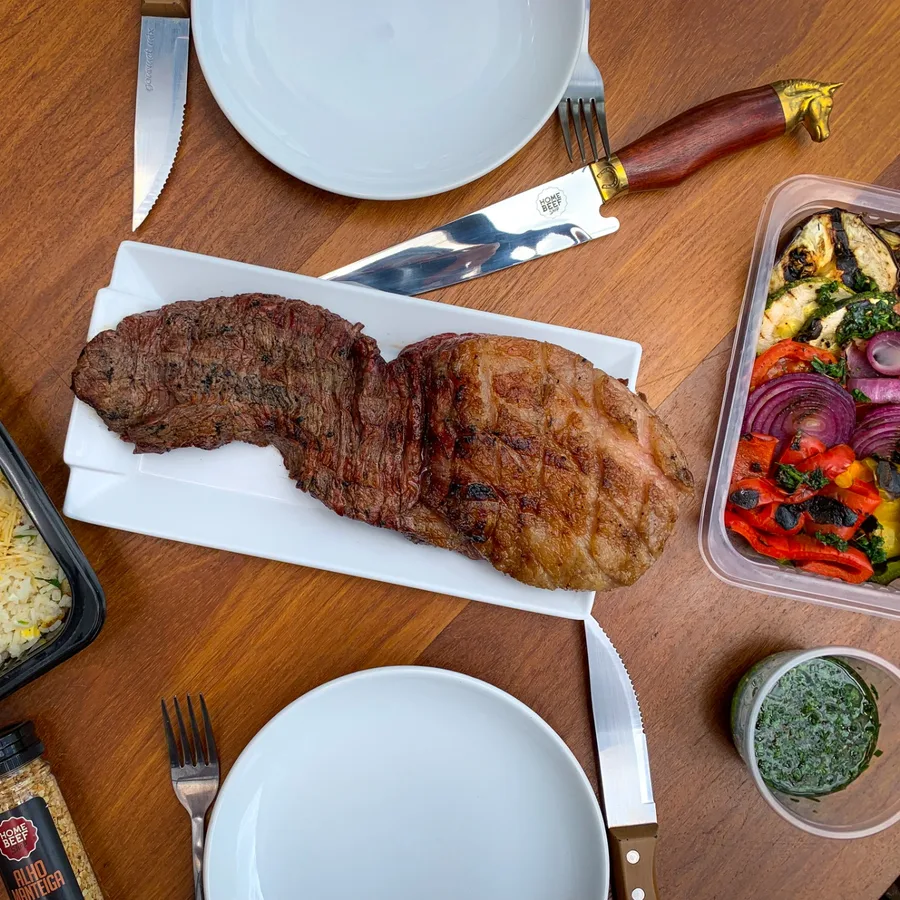 Cortes assados na brasa com arroz e legumes grelhados servidos na mesa da Home Beef Shop